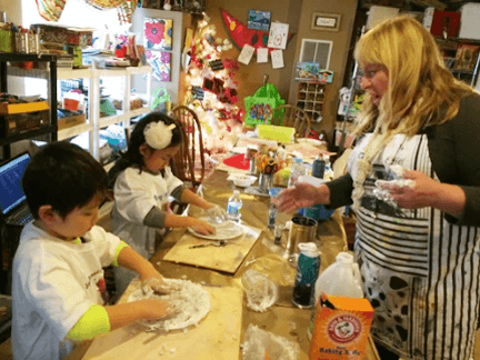 Connie guiding young artists through a clay project