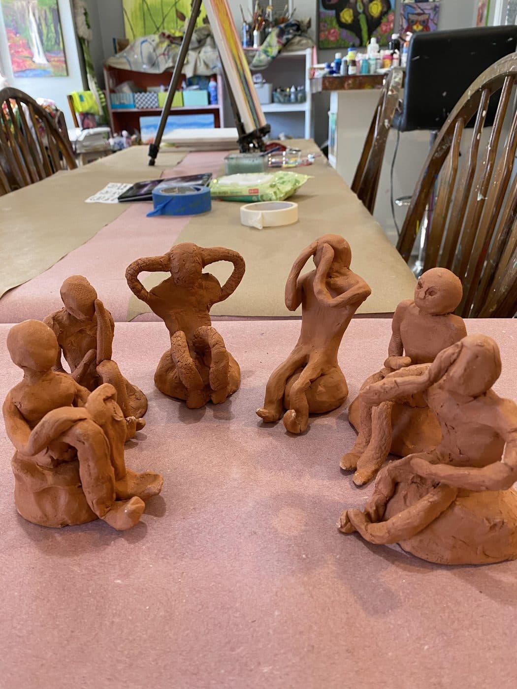 A circle of hand-sculpted clay figures made by students