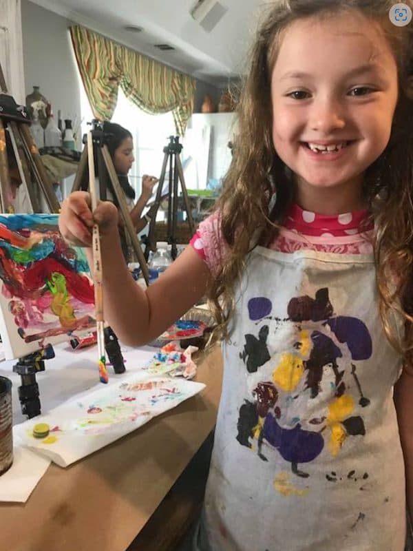 All smiles behind the easel