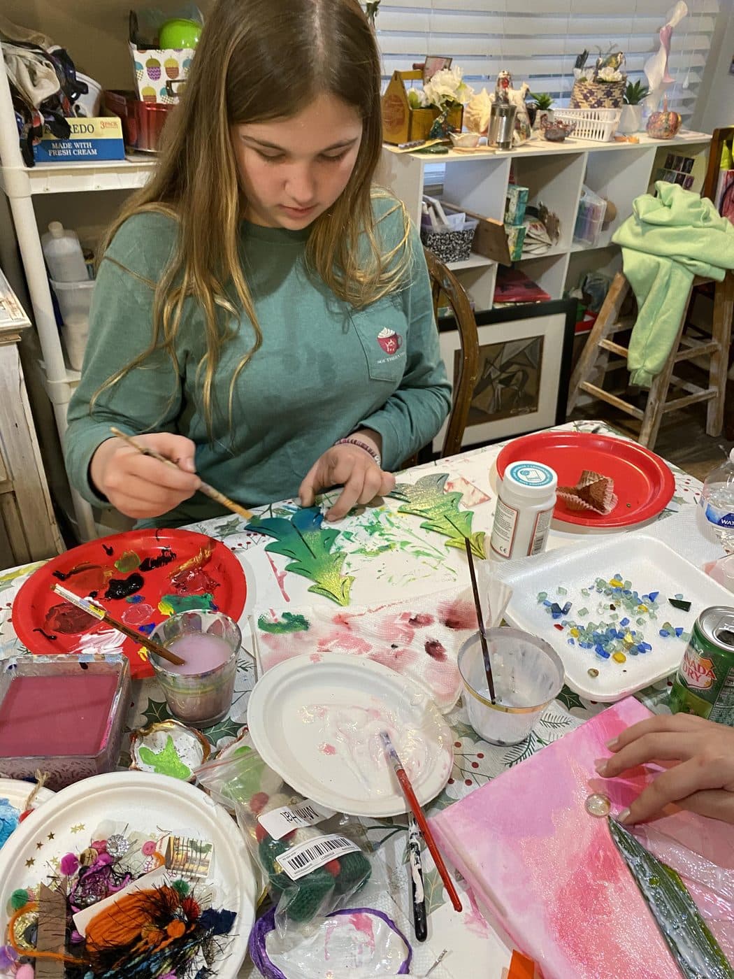 A student mixing colors at the painting table