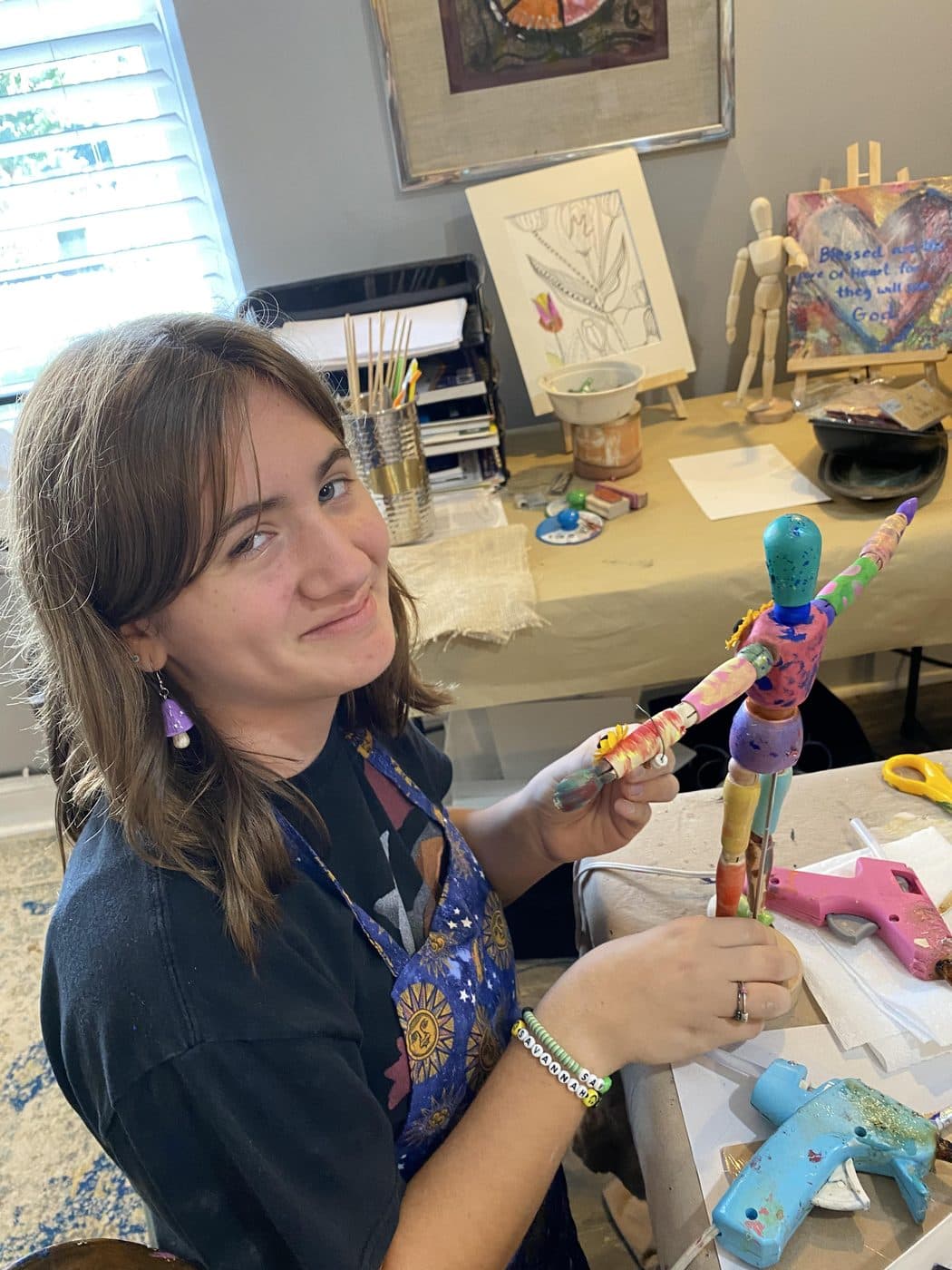 A student showing off a hand-painted wooden figure